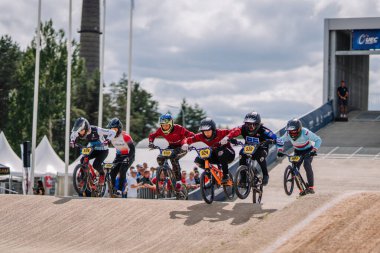 Valmiera, Letonya - 12 Temmuz 2025: BMX Avrupa Şampiyonası. Çeşit çeşit BMX sürücüleri toprak pistte yarışıyor ve arka planda izleyiciler izliyor