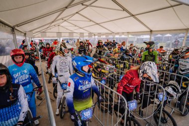Valmiera, Letonya - 12 Temmuz 2025: BMX Avrupa Şampiyonası. Canlı formalı genç BMX sürücüleri yarışma salonunda sırada bekliyorlar.