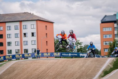 Valmiera, Letonya - 12 Temmuz 2025: BMX Avrupa Şampiyonası. Bir şehir ortamında yarışan erkek BMX sürücüleri havada süzülüyorlar.