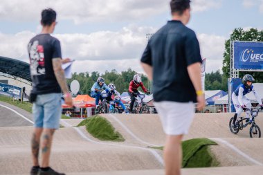 Valmiera, Letonya - 12 Temmuz 2025: BMX Avrupa Şampiyonası. BMX yarışçıları izleyicilerle pistte yarışıyor.