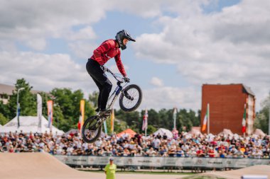 Valmiera, Letonya - 12 Temmuz 2025: BMX Avrupa Şampiyonası. BMX sürücüsü yarışma sırasında aşağıda coşkulu bir kalabalık tarafından izleniyor.