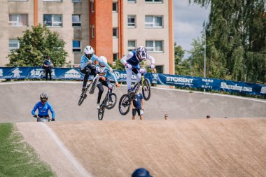 Valmiera, Letonya - 12 Temmuz 2025: BMX Avrupa Şampiyonası. Erkek BMX sürücüleri bisiklet yarışında izleyicilerle sıçrama yapıyorlar.