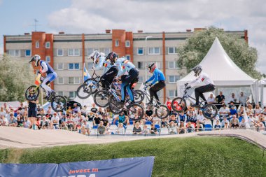Valmiera, Letonya - 12 Temmuz 2025: BMX Avrupa Şampiyonası. Bir grup BMX sürücüsü kalabalığın izlediği bir yarışmada hava taktikleri uyguluyor.
