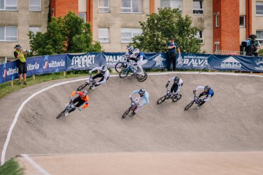 Valmiera, Letonya - 12 Temmuz 2025: BMX Avrupa Şampiyonası. Bir grup BMX yarışçısı bir virajda seyreden seyircilerle birlikte ilerliyorlar.