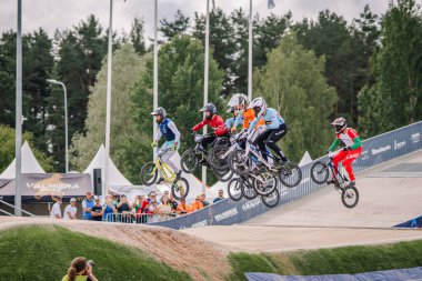 Valmiera, Letonya - 12 Temmuz 2025: BMX Avrupa Şampiyonası. Bir yarışa katılan bir grup genç BMX sürücüsü, yarışmada hız ve çeviklik gösteriyor.