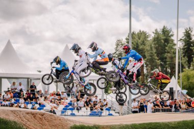 Valmiera, Letonya - 12 Temmuz 2025: BMX Avrupa Şampiyonası. Bir grup BMX sürücüsü canlı bir açık hava yarışında havada sıçrama yapıyor.