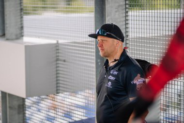 Valmiera, Letonya - 12 Temmuz 2025: BMX Avrupa Şampiyonası. Yarış teçhizatlı bir adam yarış pistinin yanında durur, konsantrasyonla eylemi gözlemler.