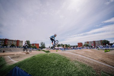 Valmiera, Letonya - 12 Temmuz 2025: BMX Avrupa Şampiyonası. BMX sürücüsü, bir bisiklet yarışında izleyicilerle hava taktikleri uyguluyor.