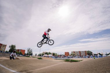 Valmiera, Letonya - 12 Temmuz 2025: BMX Avrupa Şampiyonası. BMX sürücüsü bir kentsel alanda yarışma sırasında pistin üzerinden atlıyor