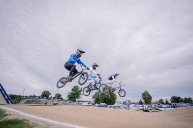 Valmiera, Letonya - 12 Temmuz 2025: BMX Avrupa Şampiyonası. BMX sürücüleri açık hava pistinde bir yarışma sırasında hava hileleri yapıyorlar