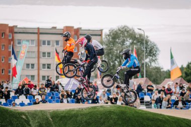 Valmiera, Letonya - 12 Temmuz 2025: BMX Avrupa Şampiyonası. BMX sürücüleri hevesli izleyicilerle rekabetçi bir yarış sırasında havadan numaralar yapıyorlar.