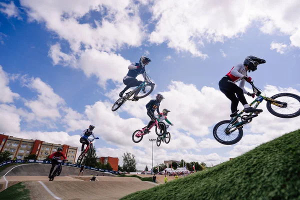 Valmiera, Letonya - 12 Temmuz 2025: BMX Avrupa Şampiyonası. BMX sürücüleri açık mavi gökyüzü altında yarışırken hava hileleri sergiliyorlar