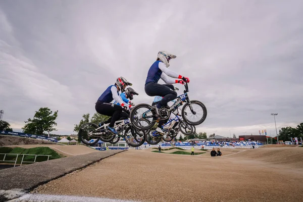 Valmiera, Letonya - 12 Temmuz 2025: BMX Avrupa Şampiyonası. BMX sürücüleri açık hava toprak pistinde bir yarışma sırasında hava hileleri yapıyorlar.