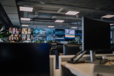 Vilnius, Litvanya - 24 Ekim 2025: Teknolojiye odaklı bir atmosferde veri analizi ve dijital bilgi sunan çok sayıda ekranın yer aldığı çağdaş ofis ayarları