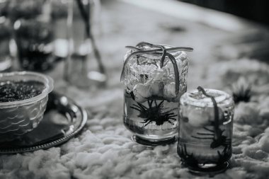 İçecekler, buz ve otlarla dolu iki şık cam kavanoz, dokulu bir yüzeyde güzelce sergileniyor, sosyal etkinlikler ve toplantılar için mükemmel.