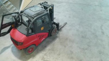 Valka, Letonya - 29 Ekim 2025: Forklift depo alanında geziniyor, kamera hareket ve çevreyi yakalamak için sorunsuz çalışıyor, operasyonel verimliliği ve tasarımı vurguluyor