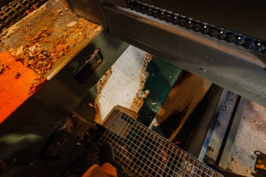 Endüstriyel marangozluk makinelerinin faaliyet halindeki yakın görüntüsü, yerdeki talaşla kesim sürecini gözler önüne sermek, işçilik ve hassasiyeti vurgulamak