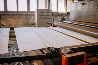 Endüstriyel baskı makinesinde, makine ve çalışma alanı elementleriyle işlenen büyük kağıtlar, ilgili üretim ve zanaatkarlığı gösteriyor