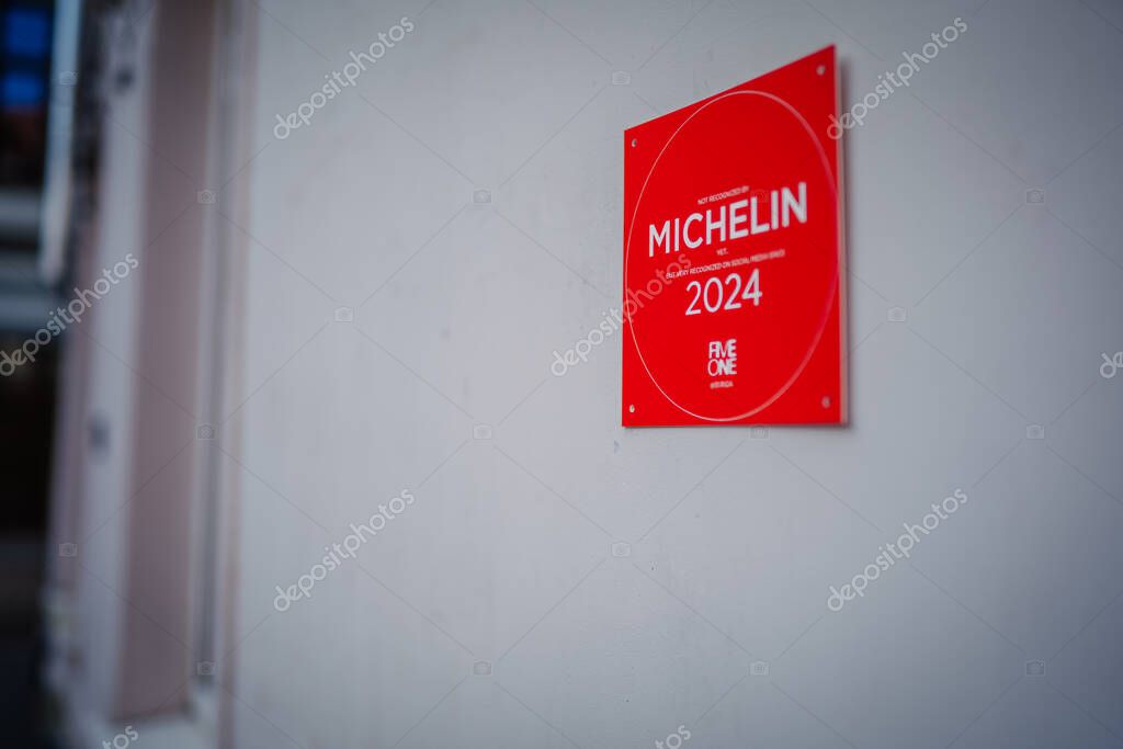 Riga, Latvia - July 25, 2025: Michelin 2024 award plaque is prominently displayed on white wall, showcasing culinary excellence and prestigious recognition