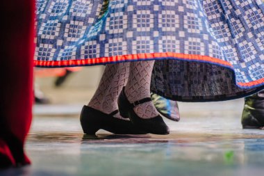 Letonya halk dansları performansında renkli kostümler ve dinamik ayak hareketleri, kültür gelenekleri ve topluluk kutlamalarının neşesi yer alıyor.