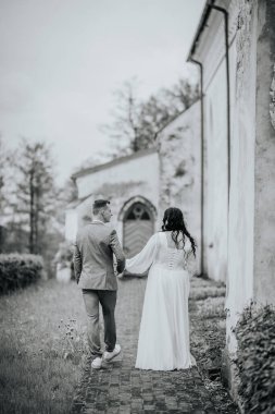 Romantik çiftler, bereketli yeşillik ve tarihi binalarla çevrili, sakin bir atmosferde sevgi ve bağın somutlaştığı, bir kaldırım taşı patikası boyunca el ele yürürler.