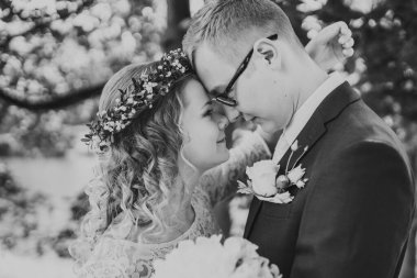 Doğayı kucaklayan bir çiftin siyah beyaz portresi, yeşilliklerle çevrili, sakin bir ortamda aşklarını ve bağlantılarını sergiliyorlar.