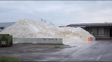 Endüstriyel ayar büyük bir sentetik alçı yığını içerir, malzemenin dokusunu ve çevresini gösteren kademeli bir kamera yakınlaşması vardır.