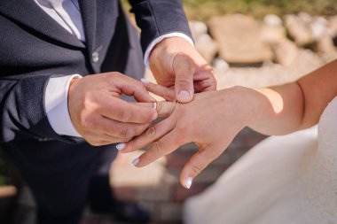 Çiftler açık havada yüzüklerini değiş tokuş ederler. Doğa ve neşe ile çevrili samimi aşk ve bağlılık anını yakalarlar.