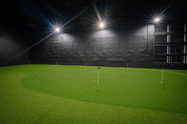Kapalı alanda golf oynamak yeşil özellikler suni çim ve parlak tepelik ışıkları kullanarak golf meraklılarına pratik yapmaları için çağdaş bir alan sağlıyor.