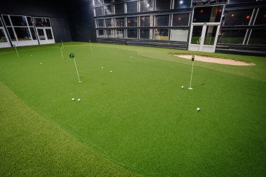 Kapalı alanda golf oynamak yapay çim, çoklu delikler ve kum tuzağı, golf meraklılarının pratik yapmaları için davet edici bir alan sağlıyor.