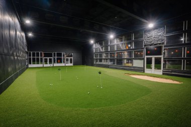 Kapalı alanda golf sahası canlı suni çim ve geniş bir alan sunuyor. Parlak ışıklarla aydınlatılıyor. Golf antrenmanı ve keyif için ideal bir ortam sağlıyor.