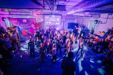 Riga, Letonya - 24 Ekim 2025 Cadılar Bayramı partisi. Çocuklar renkli ışıkları olan ve kapalı bir mekanda eğlenceli bir atmosferi olan canlı bir dans partisinin tadını çıkarıyorlar.