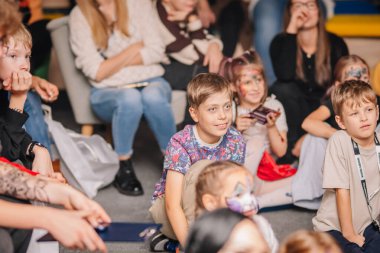 Riga, Letonya - 24 Ekim 2025 Cadılar Bayramı partisi. Çocuklar neşeli bir olaya katılıyorlar. Yüzlerini boyayıp renkli dekorasyonlar yapıyorlar ve neşeli bir ortam yaratıyorlar.