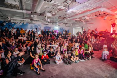 Riga, Letonya - 24 Ekim 2025 Cadılar Bayramı partisi. Çocuklar ve yetişkinlerden oluşan kalabalık renkli dekorlu, kapalı bir alanda bir şenlik etkinliğinde