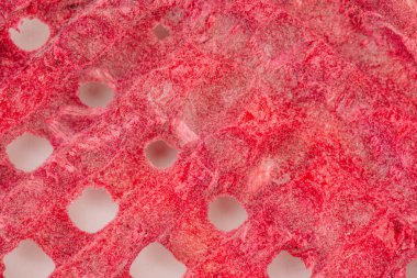 Dondurulmuş çilekler dokulu bir yüzeye dizilmiş, canlı kırmızı renklerini ve eşsiz şekillerini vurguluyor, sağlıklı atıştırmalıklar, pişirme veya metin için fotokopi alanı ile mutfak dekorasyonu için mükemmel.