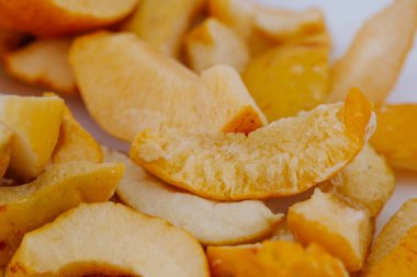 Dondurulmuş meyve dilimlerinin renkli bir çeşidi, çeşitli doku ve şekillere sahip, temiz beyaz bir arka planda güzelce düzenlenmiş, sağlıklı atıştırma ve mutfak yaratıcılığı için ideal.