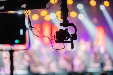 Kamera kurulumu, parlak sahne ışıkları ve müzisyenlerin sahne aldığı ve seyirciler için enerjik bir atmosfer yaratan canlı bir konsere odaklandı.