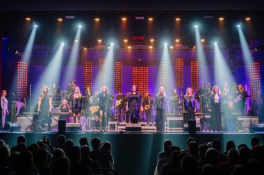 Valmiera, Letonya - 29 Aralık 2025: Yamaha. Konser performansı, çeşitli müzisyenleri canlı ışıklandırmayla ve coşkulu bir dinleyiciyle sahnede sergiliyor.