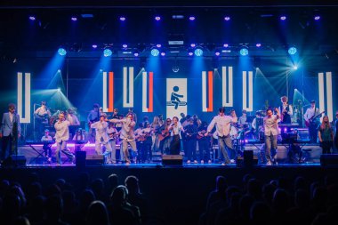 Valmiera, Letonya - 29 Aralık 2025: Yamaha. Değişik müzisyenlerin sahne aldığı dinamik canlı konser. Canlı ışıklar ve coşkulu bir seyirci performansın keyfini çıkarıyor.