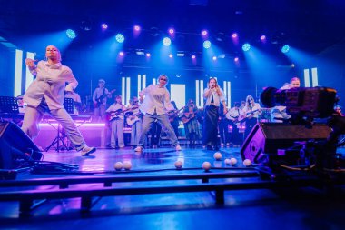 Valmiera, Letonya - 29 Aralık 2025: Yamaha. Genç dansçılar, parlak ışıklar ve coşkulu seyircilerle dolu canlı bir konserde yeteneklerini sahnede sergilerler.