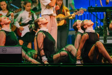 Valmiera, Letonya - 29 Aralık 2025: Yamaha. Dansçılar, canlı bir müzikal performans sırasında zarif kostümlerle sahnede yeteneklerini sergiliyorlar.