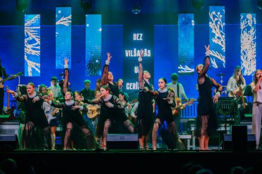 Valmiera, Letonya - 29 Aralık 2025: Yamaha. Dansçılar, canlı bir konser atmosferinde müzisyenlerle birlikte sahnedeki performanslarıyla seyircileri büyülüyor.