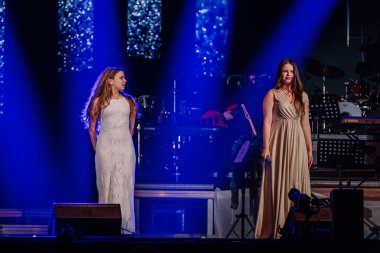 Valmiera, Letonya - 29 Aralık 2025: Yamaha. Kadın vokalistler sahnede canlı ışıklandırma ve müzik aletleriyle çekici bir atmosfer yaratıyorlar.