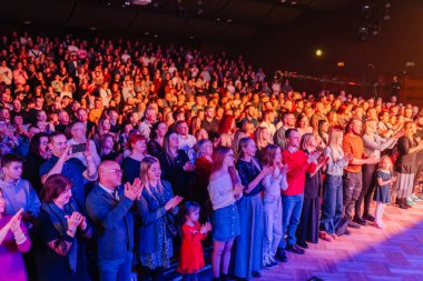 Valmiera, Letonya - 29 Aralık 2025: Yamaha. Çeşitli bireylerden oluşan coşkulu bir kalabalık canlı bir kapalı mekan ortamında konser veriyor ve eğleniyor.