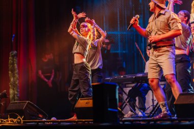 Valmiera, Letonya - 29 Aralık 2025: Yamaha. Dansçı, renkli ışıklar ve canlı atmosfer yaratan müzisyenlerle sahnede enerjik bir performans sergiliyor