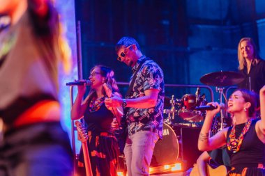 Valmiera, Letonya - 29 Aralık 2025: Yamaha. Çeşitli müzisyenler sahnede canlı bir atmosfer yaratan renkli ışıklar ve enstrümanlarla enerjik bir performans sergiliyorlar.