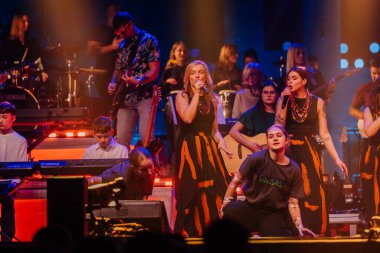 Valmiera, Letonya - 29 Aralık 2025: Yamaha. Çeşitli müzisyen grupları canlı performanslar sergilemekte. Renkli ışıklar ve coşkulu seyirciler gösterinin keyfini çıkarmaktadır.