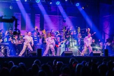 Valmiera, Letonya - 29 Aralık 2025: Yamaha. Değişik sanatçıların sahne aldığı dinamik dans performansı renkli ışıklar ve müzik aletleriyle büyüleyici bir atmosfer yaratıyor.