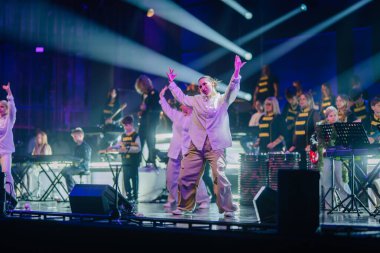 Valmiera, Letonya - 29 Aralık 2025: Yamaha. Renkli ışıklarla aydınlatılmış dansçılar ve müzisyenlerin canlandırdığı dinamik sahne performansı heyecan verici bir ortam yaratıyor.