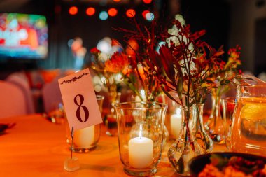 Renkli çiçekleri ve mumları olan güzel bir masa, sekiz numaralı işareti sergiliyor, neşeli bir kutlama için ortam yaratıyor ya da toplanıyor.